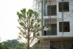 engenheiro e arquiteto trabalhando em a construção site, dupla verificação planos e processo. foto