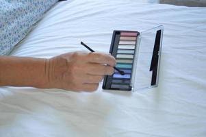 mulher fazendo sua própria maquiagem em um quarto de hotel foto