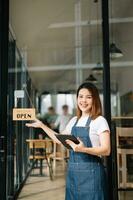 mulher café fazer compras proprietário segurando bloco de anotações e digital tábua pronto para receber ordens dentro cafeteria restaurante. foto