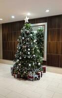 uma ampla lindo Novo ano árvore com presentes dentro a lobby do uma hotel dentro Washington foto