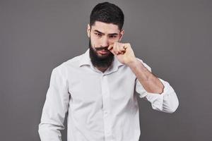 hipster com cara séria. sentimento e emoções. cara ou barbudo em fundo cinza. moda e beleza do barbeiro. homem com barba comprida e bigode, copie o espaço foto