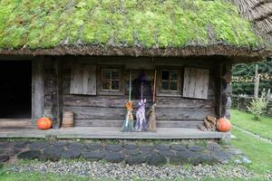 três diferente vassouras do bruxas ficar de pé às a velho de madeira cabana casa foto