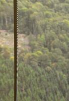 ferro cabo a partir de a transporte sistema do a funicular em a fundo do uma verde montanha floresta foto