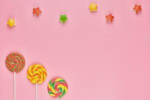 pirulito doce e doces no fundo rosa foto