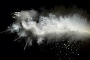 branco pó explosão.congelar movimento do branco poeira partículas em Preto fundo. foto