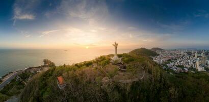 aéreo Visão do Vung tau cidade, Vietnã, panorâmico Visão do a pacífico e lindo costeiro cidade atrás a estátua do Cristo a rei em pé em montar nho dentro Vung tau cidade. foto