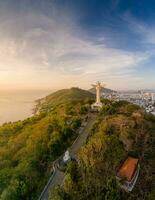 aéreo Visão do Vung tau cidade, Vietnã, panorâmico Visão do a pacífico e lindo costeiro cidade atrás a estátua do Cristo a rei em pé em montar nho dentro Vung tau cidade. foto