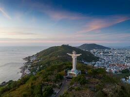 aéreo Visão do Vung tau cidade, Vietnã, panorâmico Visão do a pacífico e lindo costeiro cidade atrás a estátua do Cristo a rei em pé em montar nho dentro Vung tau cidade. foto