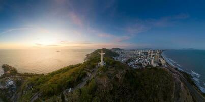 aéreo Visão do Vung tau cidade, Vietnã, panorâmico Visão do a pacífico e lindo costeiro cidade atrás a estátua do Cristo a rei em pé em montar nho dentro Vung tau cidade. foto