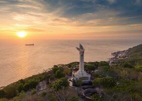 aéreo Visão do Vung tau cidade, Vietnã, panorâmico Visão do a pacífico e lindo costeiro cidade atrás a estátua do Cristo a rei em pé em montar nho dentro Vung tau cidade. foto