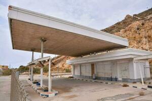 a esvaziar gás estação com uma ampla construção dentro a fundo foto