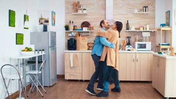 romântico casal dançando dentro cozinha enquanto Comida é obtendo lendo em gás fogão. alegre feliz jovem família juntos dança. Diversão amor afeição romance lazer romântico música para diversão foto