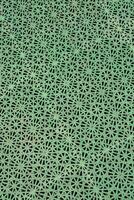 uma verde estampado superfície com buracos dentro isto foto