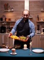 namorado preparando romântico jantar para esposa dentro cozinha. homem preparando festivo jantar com saudável comida, cozinhando para dele mulher uma romântico jantar, foto