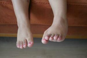 Os pés da menina da criança de 5 anos fecham-se foto