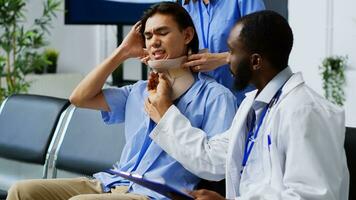 médico funcionários removendo cervical colarinho fora do ásia paciente com pescoço fratura, lidando com fisica dor depois de acidente. médico e enfermeira dando Apoio, suporte para ferido homem, remédio serviço apoiar. foto