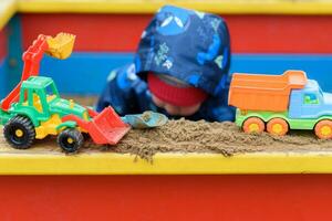 a criança tocam carros em a Parque infantil foto