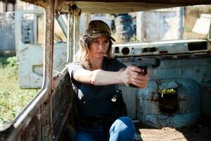 uma menina com uma pistola dentro dela mão aprende para tiro às a tiroteio alcance foto