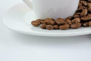 uma copo do café em uma branco mesa. café feijões em uma pires fechar acima. foto