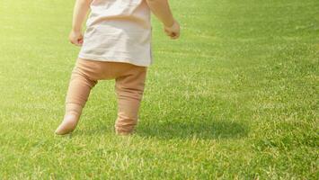 primeiro bebê passos. pequeno bebê Aprendendo para andar. foto