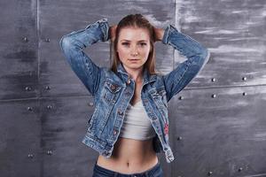 moda, roupas, conceito de pessoas. mulher jovem e atraente sexy com jaqueta jeans. garota está posando no estúdio foto