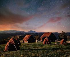 fantásticas pilhas de céu estrelado e aldeias de montanha tradicionais. cárpatos, ucrânia foto