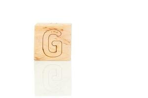 de madeira cubos com cartas g em uma branco fundo foto