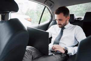 homem de negócios usando laptop para trabalhar no carro foto