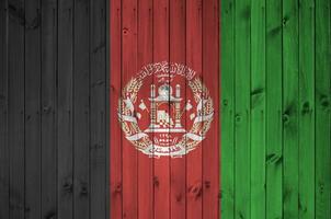 Afeganistão bandeira retratado dentro brilhante pintura cores em velho de madeira muro. texturizado bandeira em rude fundo foto