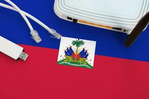 Haiti bandeira retratado em mesa com Internet rj45 cabo, sem fio USB Wi-fi adaptador e roteador. Internet conexão conceito foto