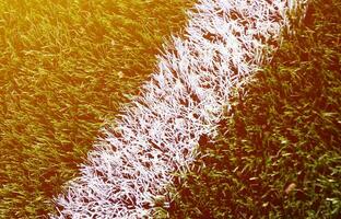 listra branca em um campo de futebol de grama artificial verde brilhante foto