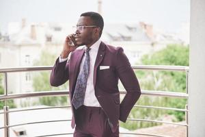 retrato de um jovem empresário afro-americano falando de terno ao telefone foto