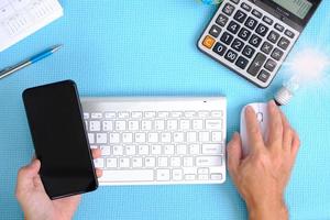 mão trabalhando computador na mesa, vista superior no espaço de trabalho com equipamento de escritório foto