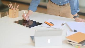 um designer profissional está trabalhando em um tablet moderno para projetar seu projeto futuro em um escritório confortável. foto