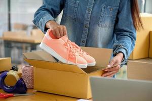 vendedores online estão embalando sapatos em caixas para entregar aos clientes. foto