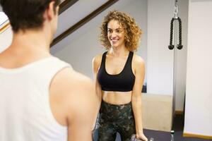 Forte sorridente desportista exercício com ginástica companheiro dentro Academia foto