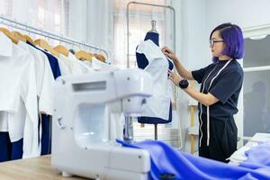 elegante freelance costureira é prendendo dela marcação musselina para Novo vestir de prendendo para manequim enquanto trabalhando dentro a artístico oficina estúdio para moda Projeto e roupas o negócio indústria foto