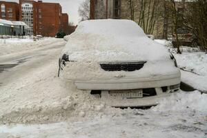 carro enterrado dentro neve em inverno rua depois de neve remoção processo foto