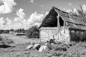 linda e velha casa de fazenda abandonada na zona rural em fundo natural foto