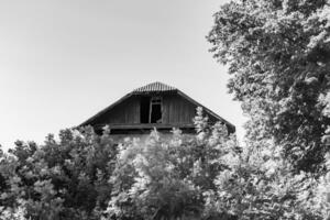 linda e velha casa de fazenda abandonada na zona rural em fundo natural foto