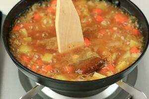 fechar acima cozinhando japonês Curry roux sopa dentro Preto panela foto