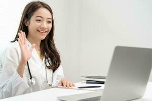 telemedicina. médico explica a medicação para a paciente de vídeo conferência. ásia médico é tratando pacientes através telecomunicação enquanto descrevendo a doença . tecnologia para saúde. foto