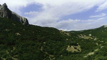 surpreendente panorama com montanhas coberto de verde tropical floresta em azul céu com nuvens em a fundo. tomada. aéreo Visão do montanhoso área com árvores e verde Relva dentro Indonésia. foto