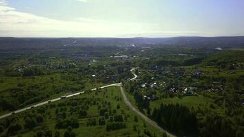 Visão do a cidade a partir de uma drone. grampo. uma verão provincial Cidade com uma pequeno estrada com carros, com baixo casas, verde ensolarado árvores por aí e uma brilhante azul ensolarado céu. foto