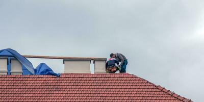 nitra, Eslováquia - 15/05/2023 faz-tudo reparar chaminés em a cobertura do uma casa. foto