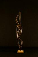 uma bronze escultura do uma mulher em uma de madeira base foto