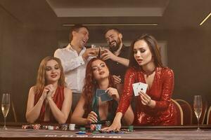 grupo do uma jovem rico amigos estão jogando pôquer às uma casino. foto