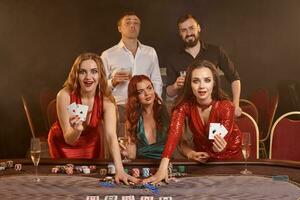 grupo do uma jovem rico amigos estão jogando pôquer às uma casino. foto