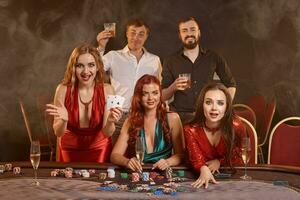 grupo do uma jovem rico amigos estão jogando pôquer às uma casino. foto