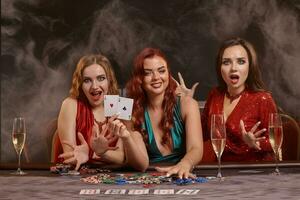grupo do uma jovem rico senhoras estão jogando pôquer às uma casino. foto